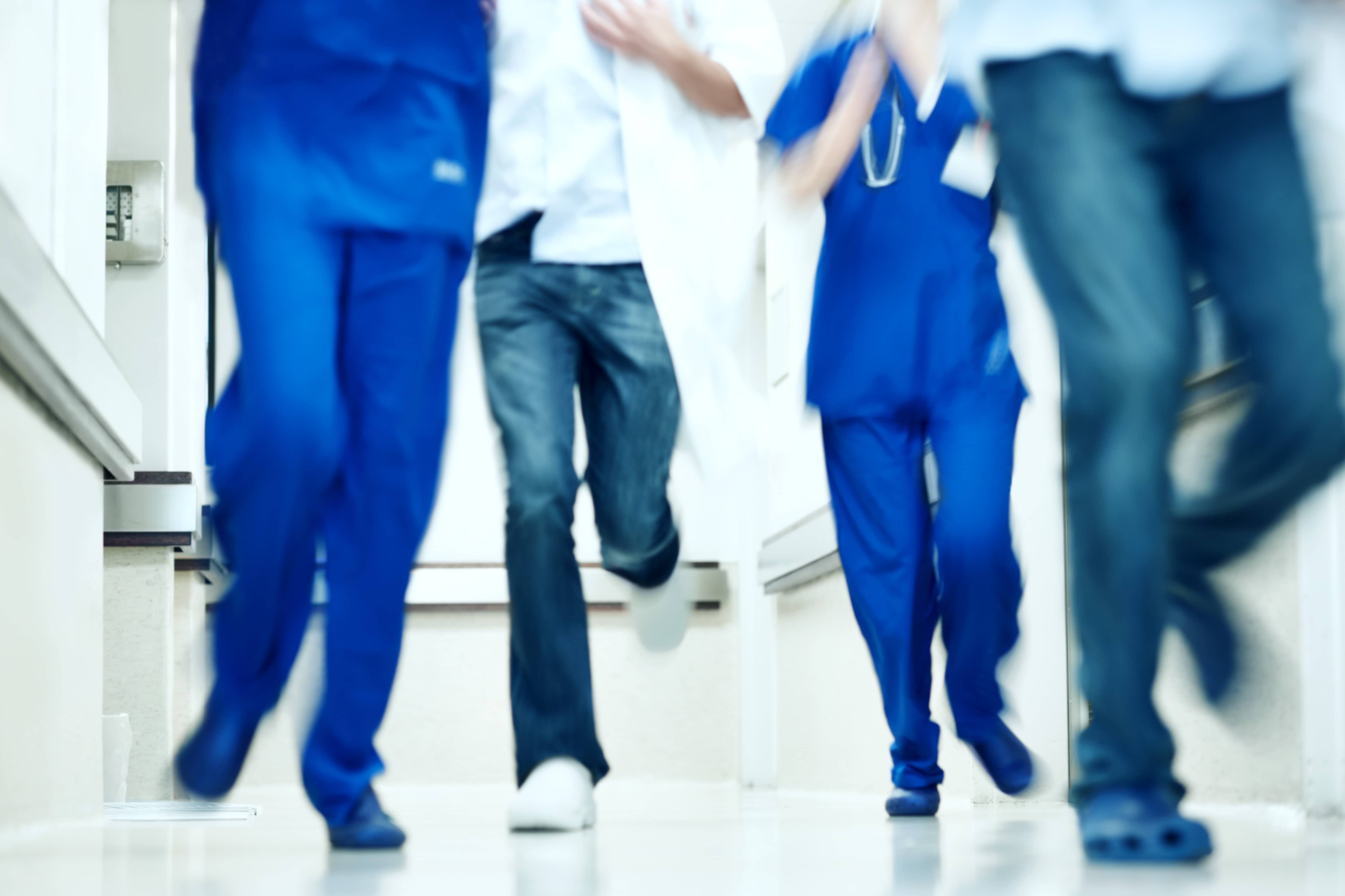 Nurses and Hospital Personnel Running Down a Hospital Hallway Nurses and Hospital Personnel Running Down a Hospital Hallway