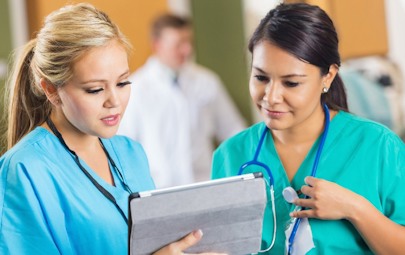 Two nurses looking at info on a tablet computer Two nurses looking at info on a tablet computer