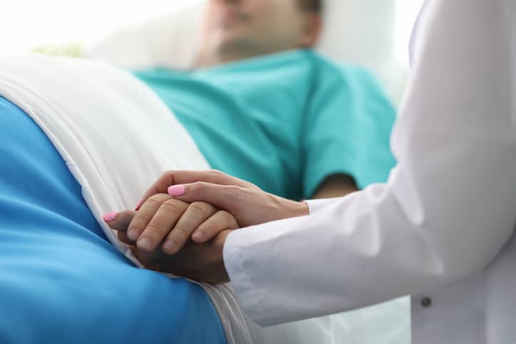 Female doctor hands hold male arm in medical hospital Female doctor hands hold male arm in medical hospital
