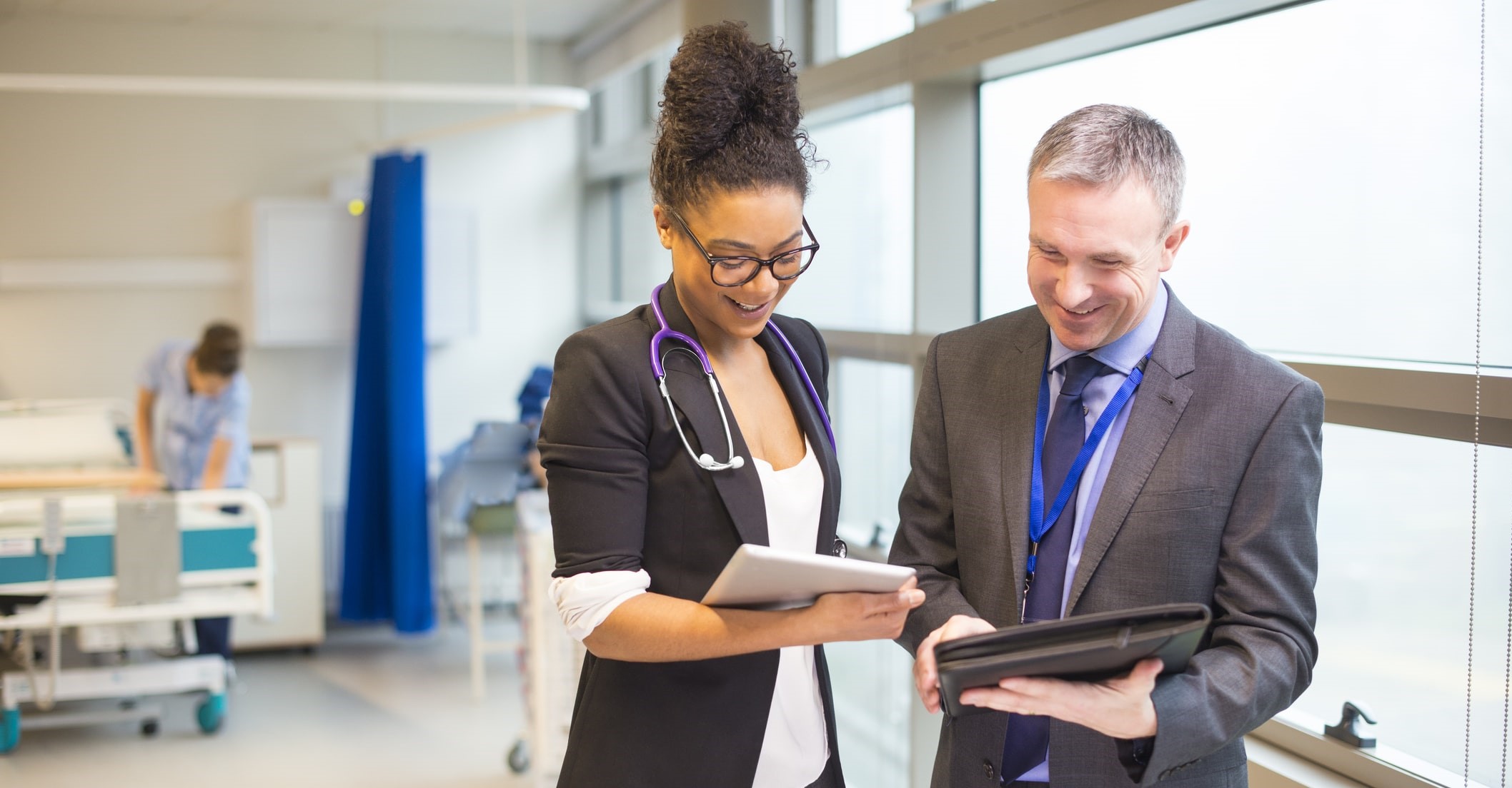 two medical professionals discussing findings on tablet two medical professionals discussing findings on tablet