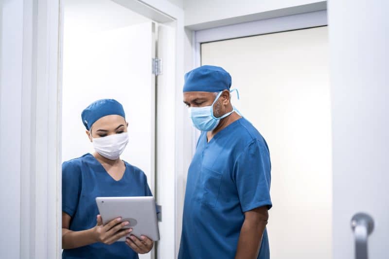 two nurses in scrubs discussing emr conversion two nurses in scrubs discussing emr conversion