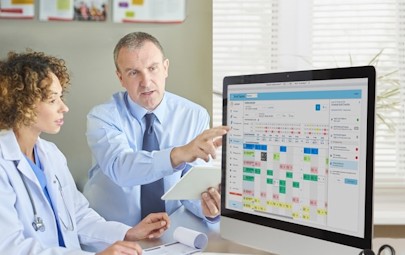 doctor and businessman reviewing computer documents doctor and businessman reviewing computer documents
