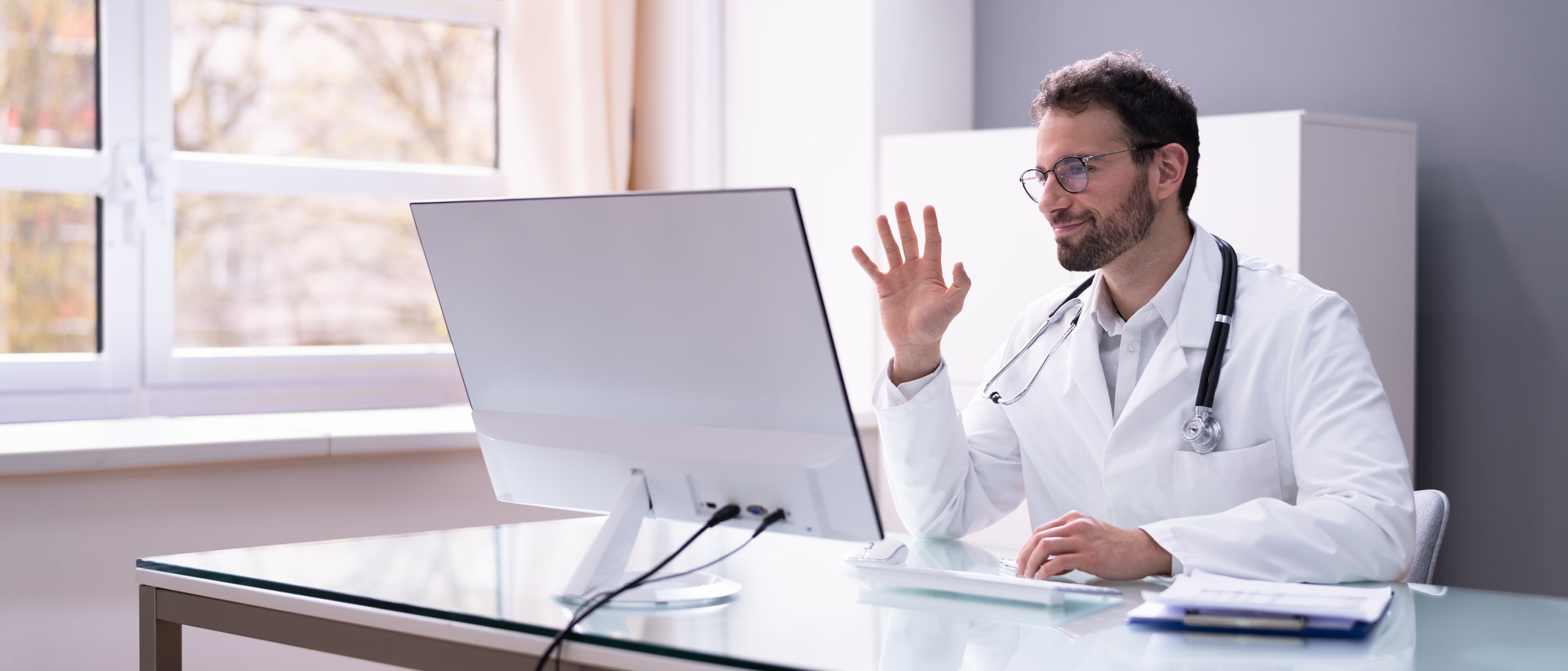 Doctor in white coat having video conference on computer Doctor in white coat having video conference on computer