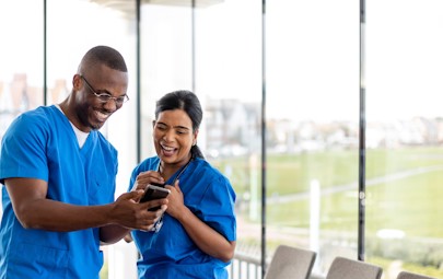 two nurses looking at phone two nurses looking at phone
