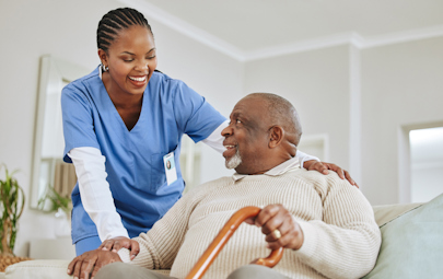 Healthcare professional smiling with a patient in his home Healthcare professional smiling with a patient in his home