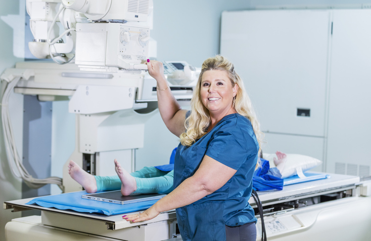 Rad tech smiling while working on a patient Rad tech smiling while working on a patient