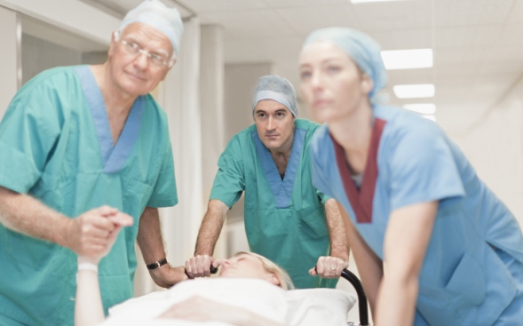 three nurses pushing a patient in a hospital bed three nurses pushing a patient in a hospital bed
