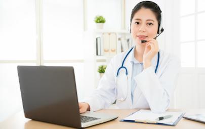Nurse sitting at desk using computer Nurse sitting at desk using computer