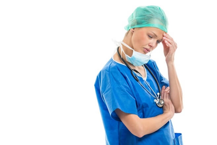 Nurse in scrubs looking tired and upset Nurse in scrubs looking tired and upset