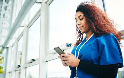 Travel nurse on passport app on her phone. Travel nurse on passport app on her phone.