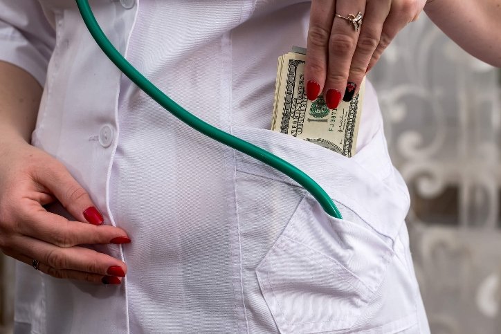 a nurse putting money in her pocket a nurse putting money in her pocket