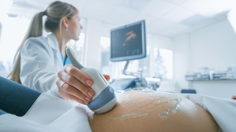 Clinician conducting an ultrasound on a patient Clinician conducting an ultrasound on a patient