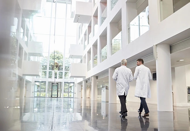 Two physicians walking through building Two physicians walking through building