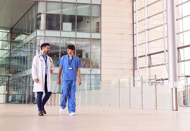 Kaiser Permanente Physicians Walking Inside a Healthcare Facility Kaiser Permanente Physicians Walking Inside a Healthcare Facility