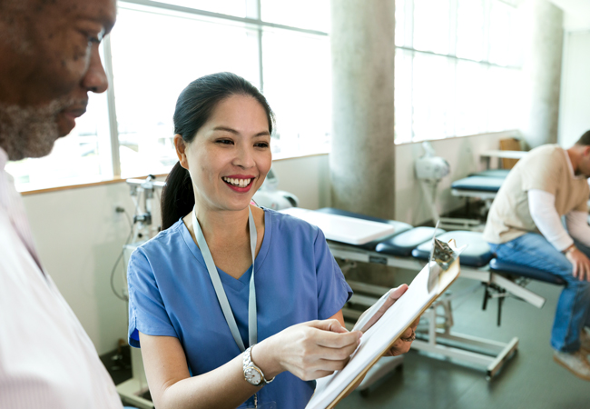 Nurse showing patient clipboard Nurse showing patient clipboard