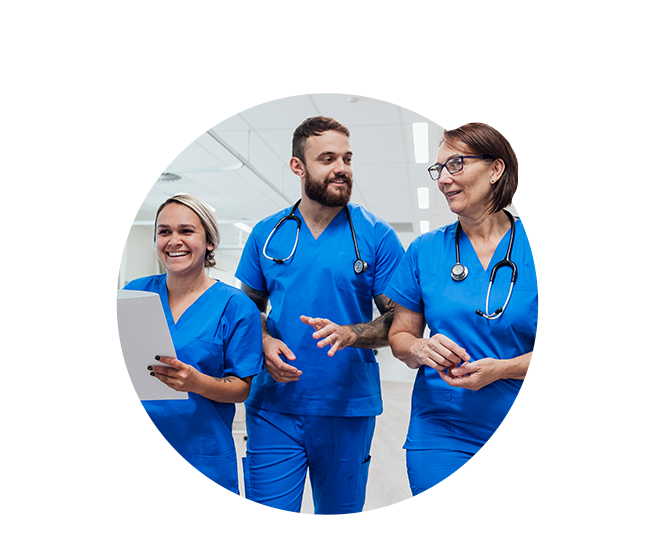 Male nurse speaking with two female nurses in hospital corridor Male nurse speaking with two female nurses in hospital corridor