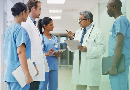 Physician consulting with medical team Physician consulting with medical team
